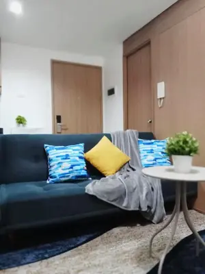 a blue couch with colorful pillows in a living room at El Aris Lushly Inn in Manila