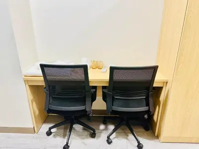 two black chairs sitting at a wooden desk at La Chicka Staycation in Coast Residences in Manila