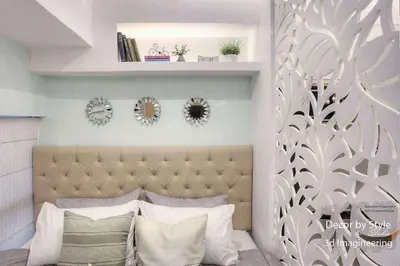 a bedroom with a bed with a headboard and some mirrors at Cozy in Manila
