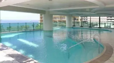 a large swimming pool with blue water in a building at Sea View Condo in Manila