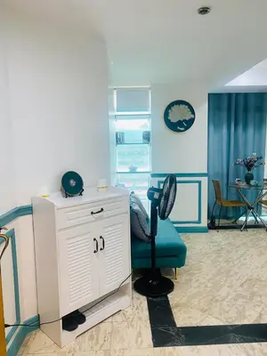 a room with a white cabinet and a blue chair at Sea View Condo in Manila