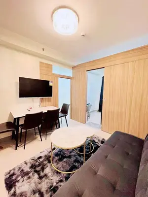 a living room with a couch and a table and a television at La Deza Shore 2 Residences Pasay Manila in Manila