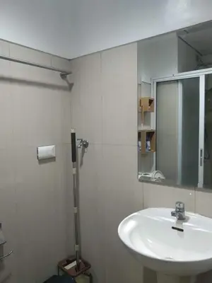 a white bathroom with a sink and a mirror at CondoDeal at Shell Residences Mall of Asia in Manila