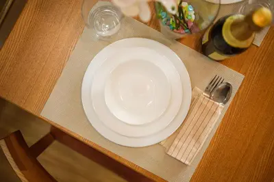 a white plate and fork on a wooden table at Azure Urban Resort Residences Parañaque City in Manila