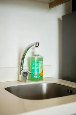 a sink with a bottle of green detergent next to it at Azure Urban Resort Residences Parañaque City in Manila