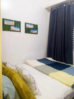 two beds sitting next to each other in a bedroom at Shore Residences by Casa Stellar in Manila