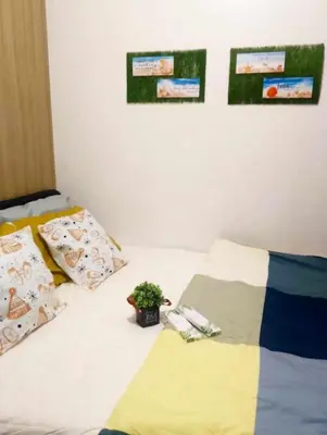 a bed with two pillows and a potted plant on it at Shore Residences by Casa Stellar in Manila
