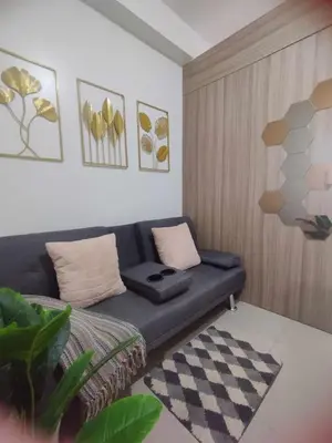 a living room with a blue couch in a room at Shore 2 Residences by Casa Stellar mall of Asia Complex in Manila