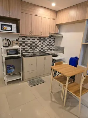 a kitchen with a table and a sink and a stove at Homey Airport bnb 1BR w Wi-Fi in Manila