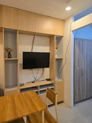 a living room with a table and a flat screen tv at Homey Airport bnb 1BR w Wi-Fi in Manila