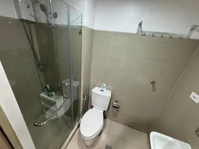a bathroom with a toilet and a glass shower at MOA Home Away From Home in Manila