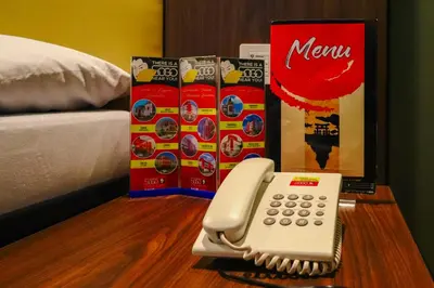 a phone sitting on a table next to a bed at Hotel Sogo Dasmariñas Cavite in Dasmariñas