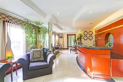 a living room with a bar and chairs at Collection O VIP Suites, Near PNR Pasay Evangelista, Makati Manila in Manila