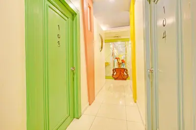 a hallway with green and orange doors and a tile floor at Collection O VIP Suites, Near PNR Pasay Evangelista, Makati Manila in Manila
