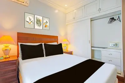 a bedroom with a large bed and a microwave at Collection O VIP Suites, Near PNR Pasay Evangelista, Makati Manila in Manila