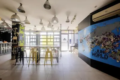 a dining room with a table and stools at Junction Hostel, Poblacion Makati Avenue, Manila in Manila