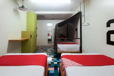two beds in a room with green and white at Junction Hostel, Poblacion Makati Avenue, Manila in Manila