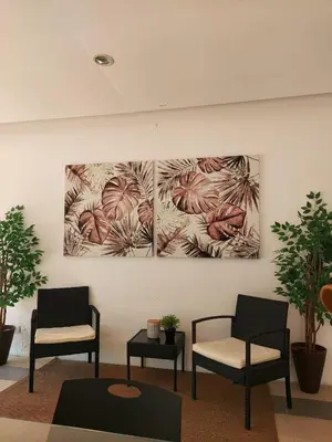 a room with two chairs and two paintings on the wall at Minimalist Studio Condo - Alabang Near Airport in Manila