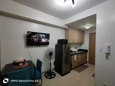 a kitchen with a refrigerator and a tv on the wall at G Spot Manila - Mall of Asia in Manila