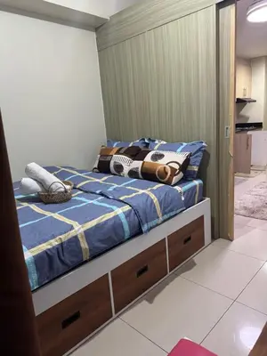 a bedroom with a bed with a blue comforter at Condo in Pasay in Manila