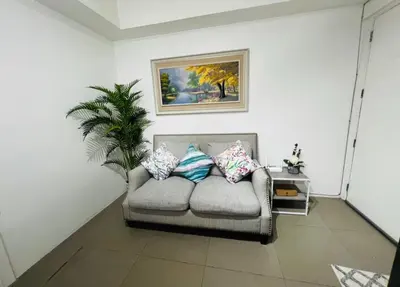 a living room with a couch with pillows on it at Porto Vita 2BR in Manila