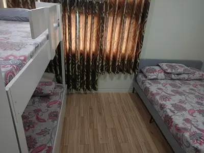 a room with two beds and a window with curtains at Holland Park Condominium Accommodation Southwoods Biñan Laguna- Max 4 Persons including kids & toddlers in Biñan