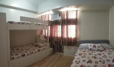 a bedroom with a bed and a bunk bed at Holland Park Condominium Accommodation Southwoods Biñan Laguna- Max 4 Persons including kids & toddlers in Biñan