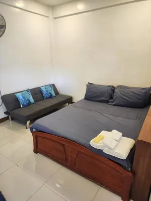a bed and a couch in a room at Solace View Rooftop in Manila