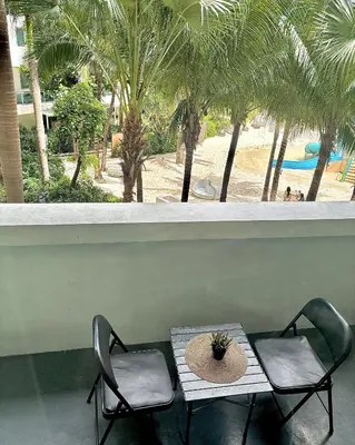 a table and two chairs with a hat on it at Metroshore Azure 2 in Manila