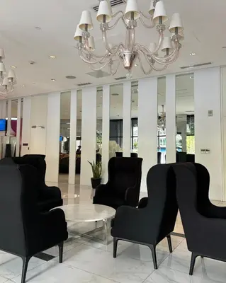 a lobby with chairs and a table and a chandelier at Metroshore Azure 2 in Manila