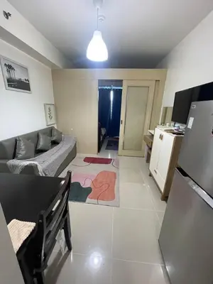 a living room with a couch and a kitchen at Minamalist modern Condo with Chic touches 