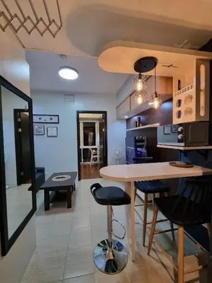 a kitchen and living room with a table and chairs at AD Camp in Manila
