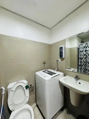 a bathroom with a white toilet and a sink at Shore Oasis Manila Near Mall of Asia in Manila