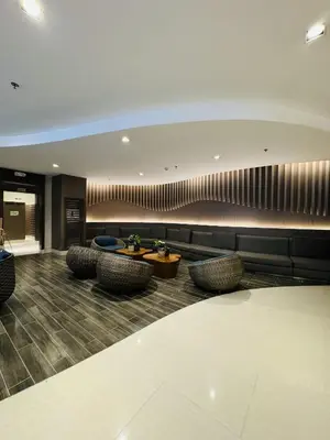 a lobby with chairs and a table in a building at Shore Oasis Manila Near Mall of Asia in Manila