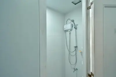 a shower with a shower head in a bathroom at Studio City Alabang Pool Access Free for 2 Wifi & Netflix SC3 in Manila
