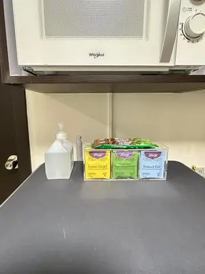two containers of food sitting on a counter with a microwave at Welcome to Jade Place at Pioneer Woodlands in Manila