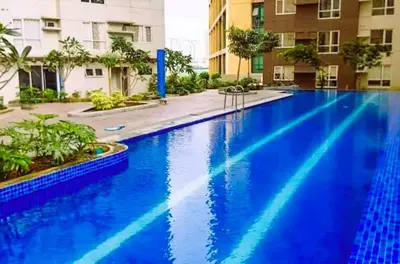 a large blue swimming pool in a building at Welcome to Jade Place at Pioneer Woodlands in Manila