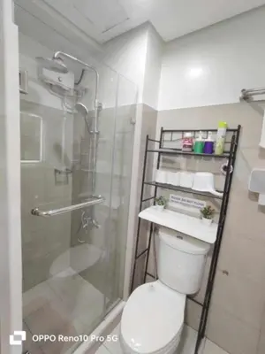 a bathroom with a toilet and a glass shower at Santorini Suite Manila-Mall of Asia in Manila