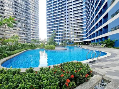 a swimming pool in the middle of a building with tall buildings at On Promo Condo 1BR Makati in Manila