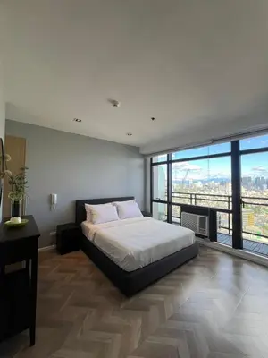 a bedroom with a bed and a large window at GRAMERCY - SKY-VIEW 1 Bed escape with POOL & SPA Access in Manila