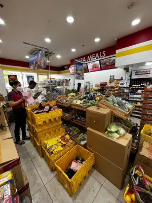 a grocery store with people standing in the produce section at Bali Inspired near BGC and NAIA in Manila