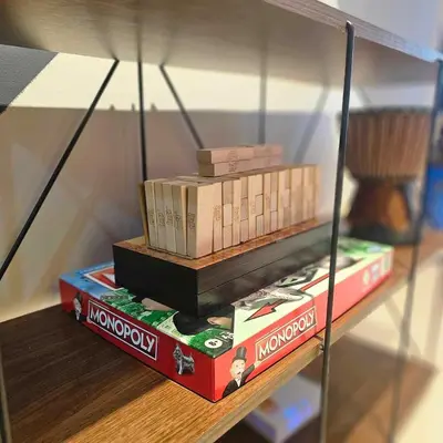 a stack of books sitting on top of a shelf at Cozy Minimalist Unit at SMDC Shore 3 in Manila