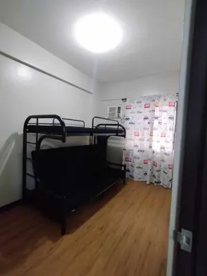 a room with a bunk bed and a wall with posters at Siena Park by Casa Stellar Bicutan Paranaque in Manila