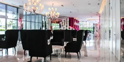 a dining room with black chairs and a table and chandeliers at Azure Urban Resort Parañaque in Manila