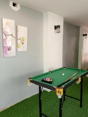 a green snooker table in a room with green carpet at Montalban Villa in General Trias