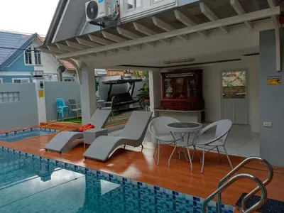 a swimming pool with chairs and a table next to a house at Montalban Villa in General Trias