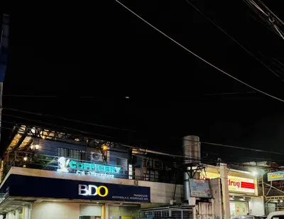 a building with a sign on it at night at Peaceful and cozy unit in Manila
