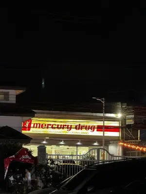 a store with a neon sign at night at Peaceful and cozy unit in Manila