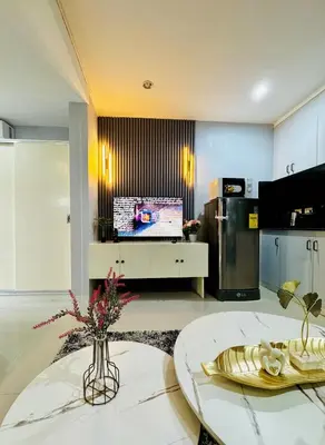 a living room with a table and a tv at Peaceful and cozy unit in Manila