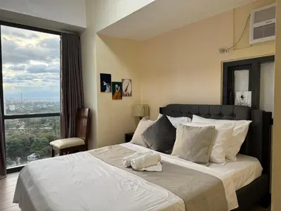 a bedroom with a large bed with a large window at 1BR Condo Near Venice Canal & BGC with Great View - 20k in Manila